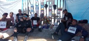 Amigos de migrantes fallecidas en el incendio de la estación migratoria, cuidan el memorial de las víctimas